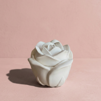 Vela artesanal Rose en recipiente blanco con forma de rosa y tapa floral decorativa.