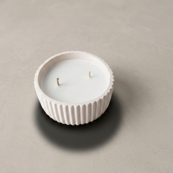 Vela artesanal Serena en recipiente blanco redondo, acanalado y de diseño minimalista.