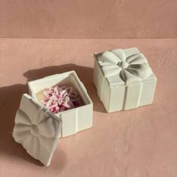Vela artesanal Blossom dentro de una caja blanca con tapa de lazo y detalle floral.