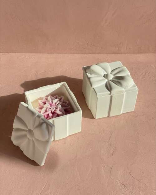 Vela artesanal Blossom dentro de una caja blanca con tapa de lazo y detalle floral.
