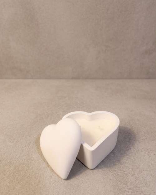 Vela artesanal Cofre Corazón en recipiente blanco con forma de corazón y tapa.
