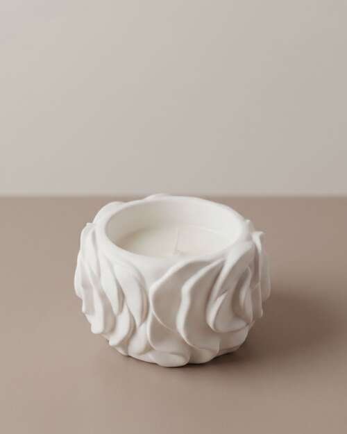 Vela artesanal Flora en un recipiente blanco de yeso con relieve floral.