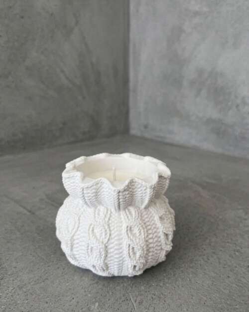 Vela artesanal Lana en recipiente blanco con textura de punto y tejido trenzado.