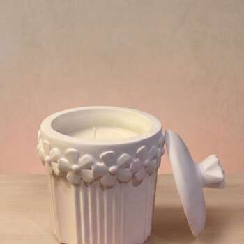 Vela artesanal Santorini en un recipiente floral blanco de yeso reutilizable.