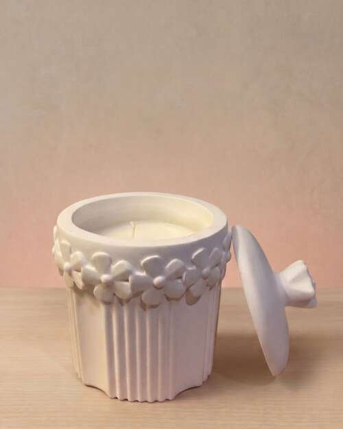 Vela artesanal Santorini en un recipiente floral blanco de yeso reutilizable.