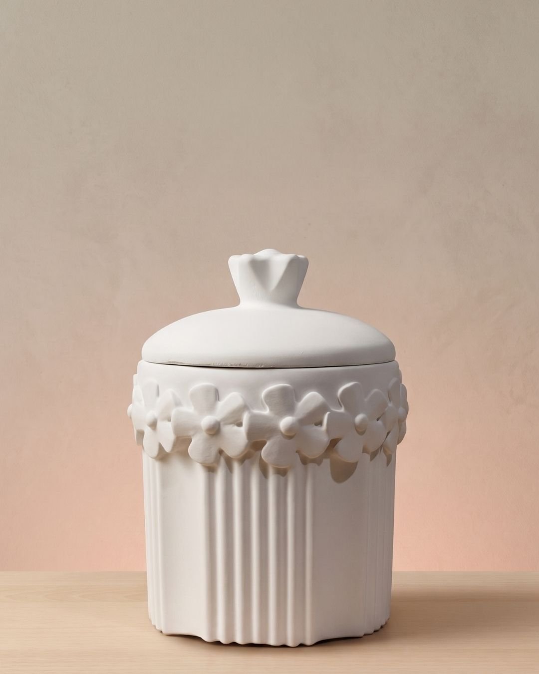 Vela artesanal Santorini en un recipiente floral blanco de yeso reutilizable.