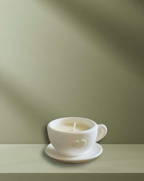 Vela artesanal Expresso presentada en una taza blanca con plato y acabado inspirado en el café.